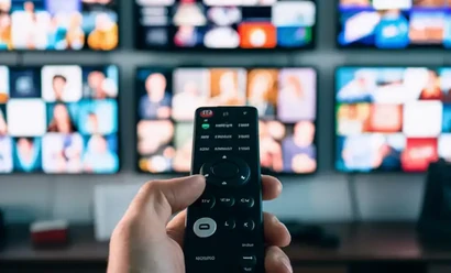 A user browsing the channel list with a remote and channel screens in the background